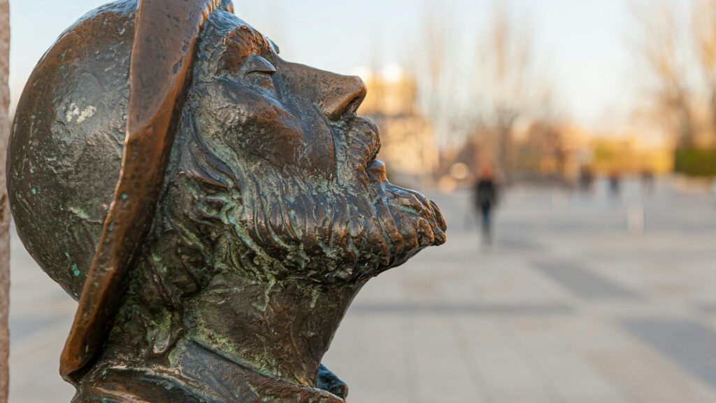 Primer plano de la estatua de bronce del peregrino en la Plaza de San Marcos de León, un icono del Camino Francés.