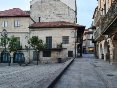 Calle con soportales y edificios de arquitectura tradicional gallega en el Camino de Santiago.