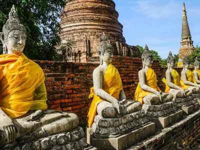 Fila de Budas con tela color naranja en Ayutthaya, Tailandia