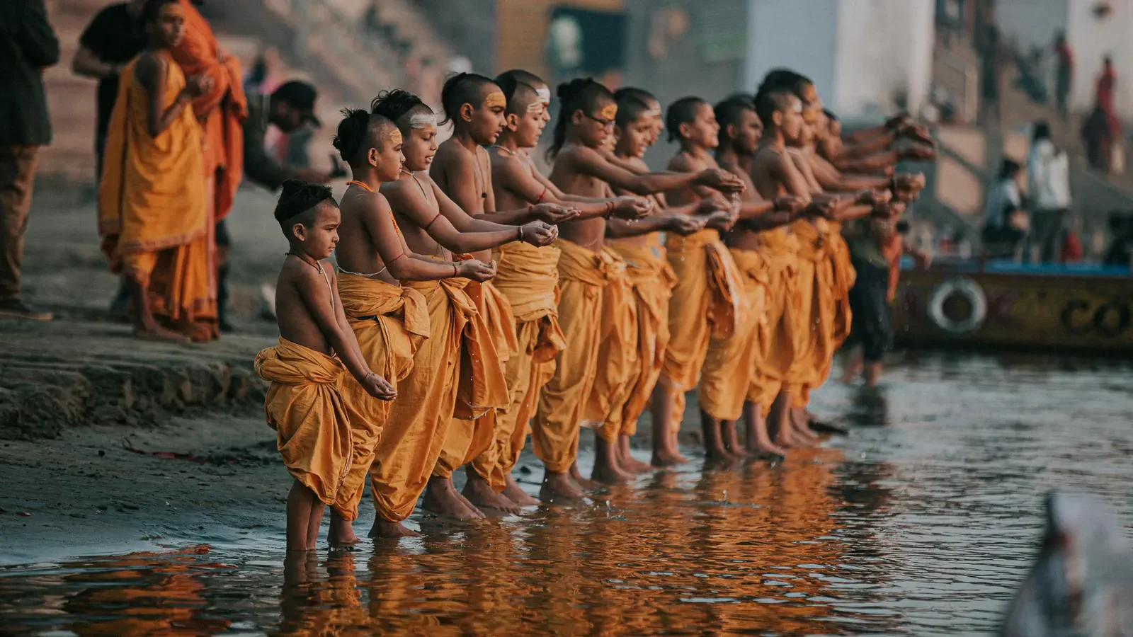 Jóvenes estudiantes hindúes en Varanasi realizando una ofrenda ritual al río Ganges al amanecer