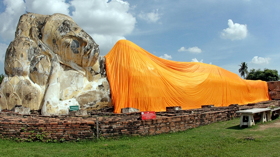 Buda yaciente tapado con enorme tela de color naranja en Ayutaya, Tailandia